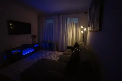 a dark living room with a couch and a television at 10 Min to NYC Quiet 1BR Flash Deal June 22 to 25 in Weehawken