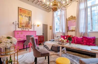 a living room with pink furniture and a chandelier at One of a kind home with NYC views in Union City