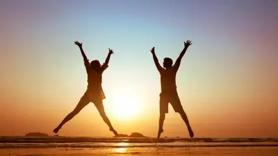 two people jumping on the beach at sunset at Lovely apartment in New York