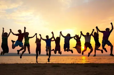 a group of people jumping on the beach at sunset at Lovely apartment in New York
