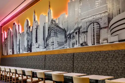 a wall mural in a restaurant with tables and chairs at Hampton Inn Times Square Central in New York