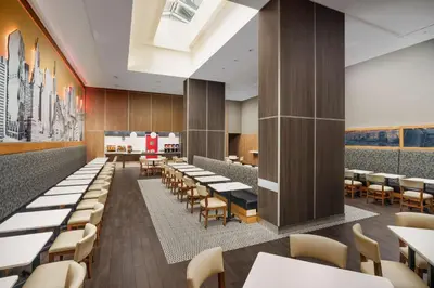 a dining room with tables and chairs in a restaurant at Hampton Inn Times Square Central in New York