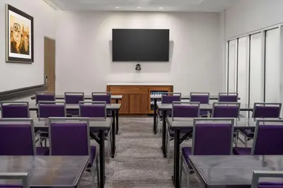a conference room with tables and purple chairs at Hampton Inn Times Square Central in New York