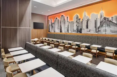 a dining room with tables and chairs and a wall mural at Hampton Inn Times Square Central in New York