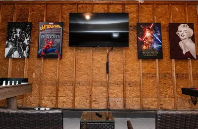a wall with posters and a tv on it at Game&GatherLodge in Tobyhanna