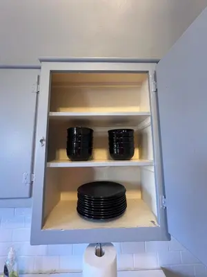 a cupboard with a stack of plates in it at Waterfront NYC skyline views in Union City