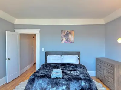 a bedroom with a large bed with blue walls at Waterfront NYC skyline views in Union City