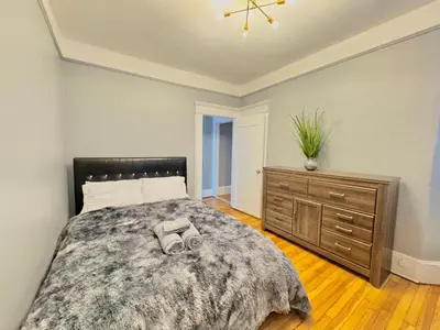 a bedroom with a large bed and a dresser at Waterfront NYC skyline views in Union City