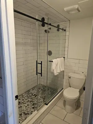 a bathroom with a glass shower with a toilet at Westview Motel in North Bergen