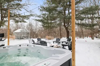 a jacuzzi tub in a snow covered yard at 4 Br Mtn Cabin Sauna Hot Tub Fire Pit Putt Putt in Albrightsville