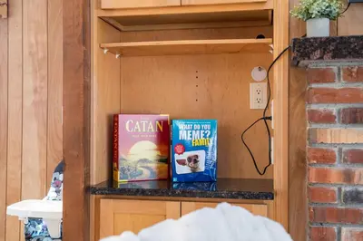 two books sitting on a shelf in a room at 4 Br Mtn Cabin Sauna Hot Tub Fire Pit Putt Putt in Albrightsville