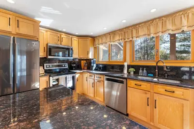 a kitchen with wooden cabinets and stainless steel appliances at 4 Br Mtn Cabin Sauna Hot Tub Fire Pit Putt Putt in Albrightsville