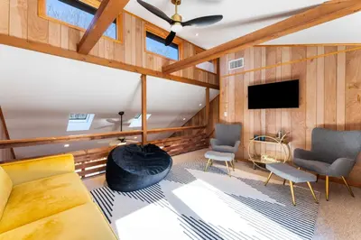 a living room with a couch and a tv at 4 Br Mtn Cabin Sauna Hot Tub Fire Pit Putt Putt in Albrightsville