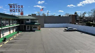 a parking lot with a car parked in front of a motel at Winslow Motel in Lyndhurst