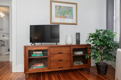 a television on a wooden entertainment center in a living room at Restaurants Coffee Colleges Bryn Mawr Has It All in Bryn Mawr