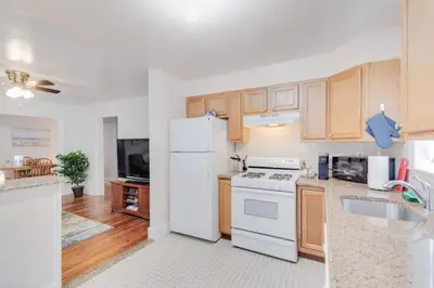 a kitchen with a white refrigerator and wooden cabinets at Colleges Bistros History Come See The Main Line in Bryn Mawr