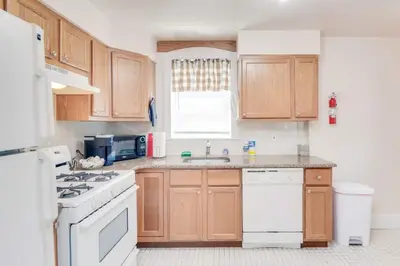 a kitchen with wooden cabinets and a white stove top oven at Colleges Bistros History Come See The Main Line in Bryn Mawr
