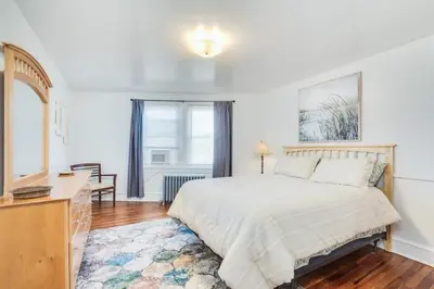 a bedroom with a bed and a dresser and a window at Colleges Bistros History Come See The Main Line in Bryn Mawr