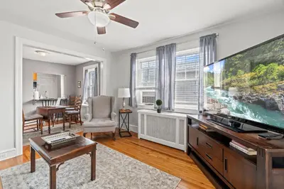 a living room with a large flat screen tv at Bryn Mawr GemBalconyDedicated Parking50TV in Bryn Mawr
