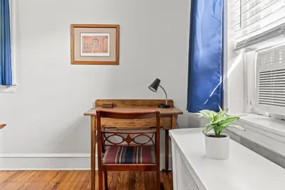 a desk with a lamp on it next to a window at Bryn Mawr GemBalconyDedicated Parking50TV in Bryn Mawr