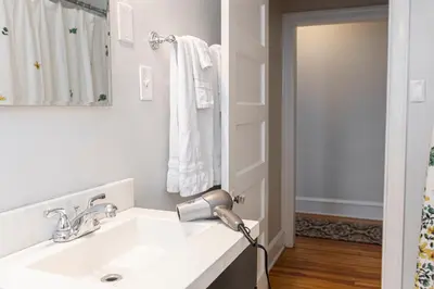 a bathroom with a sink with a blow dryer on the counter at Bryn Mawr GemBalconyDedicated Parking50TV in Bryn Mawr
