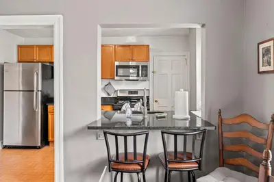 a kitchen with a table and chairs and a refrigerator at Bryn Mawr GemBalconyDedicated Parking50TV in Bryn Mawr
