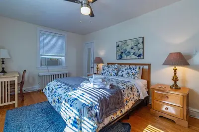 a bedroom with a bed and a dresser and a window at 2mins DTPatioParking50 Roku TV400 Mbps in Bryn Mawr