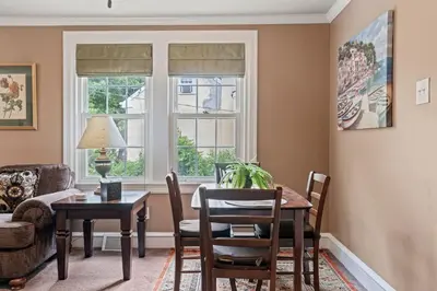 a living room with a table and chairs and windows at Stay At Our Tasteful, Private, & Elegant Abode in Devon
