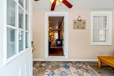 a door leading into a living room with a ceiling fan at Stay At Our Tasteful, Private, & Elegant Abode in Devon