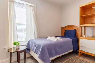 a bedroom with a blue bed and a window at Devon - Horse Show, History, Walk to Shops, Café's in Devon