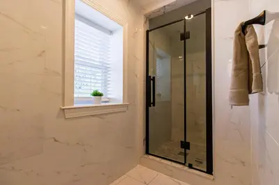 a glass shower in a bathroom with a window at Devon - Horse Show, History, Walk to Shops, Café's in Devon