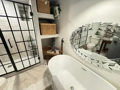 a bathroom with a tub and a large mirror at Amazing views of NYC and Patio 10 mins from NYC in Union City