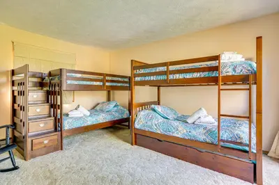 a bedroom with two bunk beds and a dresser at Walk to Beach Arrowhead Lake Home in Pocono Lake