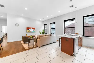 a kitchen and living room with a couch and a table at 20 MIN to Manhattan! 2BR Luxurious Comfy & Spotless in Newark