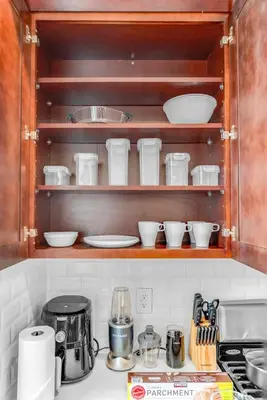 a kitchen with wooden shelves with dishes and utensils at 20 MIN to Manhattan! 2BR Luxurious Comfy & Spotless in Newark