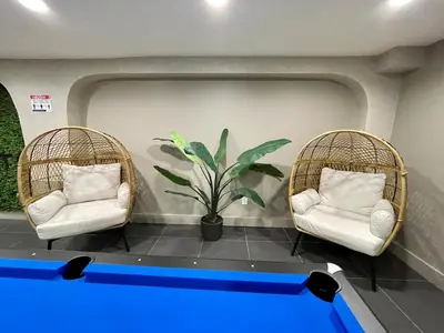 two chairs and a ping pong table in a room at 20 MIN to Manhattan! 2BR Luxurious Comfy & Spotless in Newark