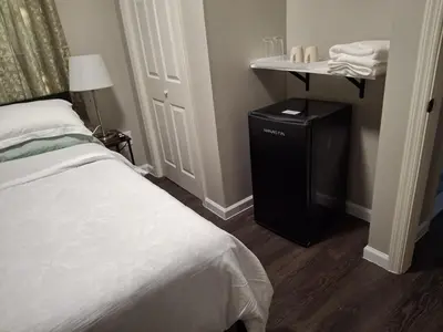 a bedroom with a bed and a table with a lamp at Two-Bedroom Home Private Parking 25 min to NYC in Teaneck