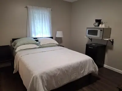 a bedroom with a bed and a tv and a window at Two-Bedroom Home Private Parking 25 min to NYC in Teaneck