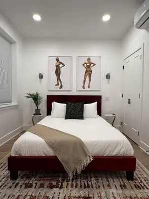a bedroom with a large bed with two pictures on the wall at Sustainable Apartment In University City in Philadelphia
