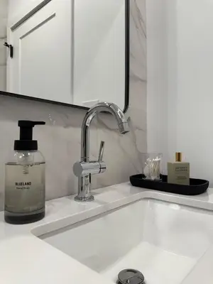 a bathroom sink with a bottle of soap and a mirror at Sustainable Apartment In University City in Philadelphia