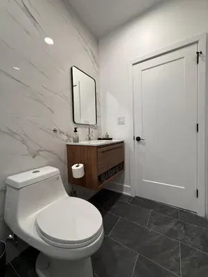 a bathroom with a white toilet and a mirror at Sustainable Apartment In University City in Philadelphia