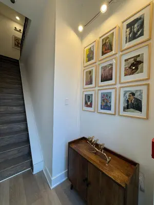 a hallway with a staircase with pictures on the wall at Sustainable Apartment In University City in Philadelphia