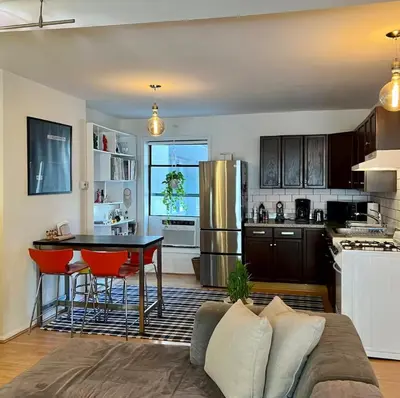 a kitchen with a couch and a table in a room at Chelsea Gem Modern 2BR Apt Prime 23rd & 7th Spot in New York