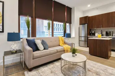 a living room with a couch and a kitchen at Charming 1BR King Bed - Just 20 Minutes from NYC! in Newark