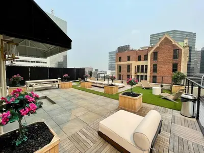 a rooftop patio with benches and flowers on a building at Charming 1BR King Bed - Just 20 Minutes from NYC! in Newark
