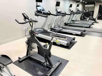 a row of exercise bikes in a gym at Charming 1BR King Bed - Just 20 Minutes from NYC! in Newark