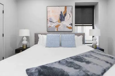 a bedroom with a large white bed with two lamps at Charming 1BR King Bed - Just 20 Minutes from NYC! in Newark