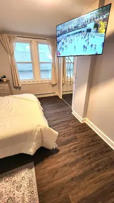 a bedroom with a bed and a flat screen tv at Friendly Home Near NYC in Little Ferry