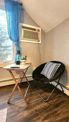 a room with a chair and a table and a window at Friendly Home Near NYC in Little Ferry