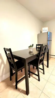 a dining room table with two chairs and a refrigerator at Friendly Home Near NYC in Little Ferry